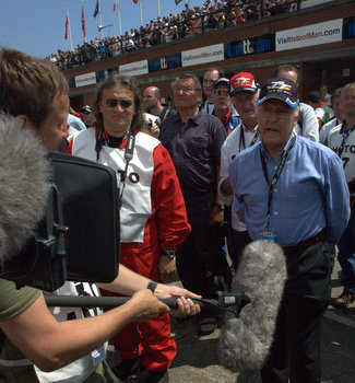 Murray Walker, pictured filming at the Centenary TT, is due to attend the show